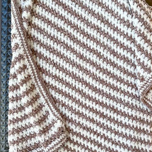 Beginner-friendly —Crochet Velvet Baby Blanket hanging on a chair