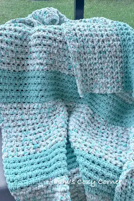 How to Crochet A Baby Blanket - Deanna’s Chunky Blanket 1 seafoam crochet blanket on a chair