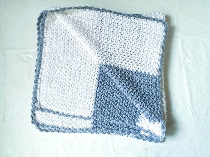 Handmade bean stitch crochet baby blanket pattern shown in crib size with soft raised texture and lightweight yarn.