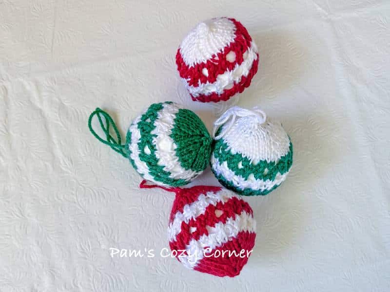 Striped Knit Bauble: A Free Knitting Pattern 2 A pair of handmade striped knit baubles in coordinating colors, ideal for Christmas tree ornaments, gift toppers, or holiday decorations.